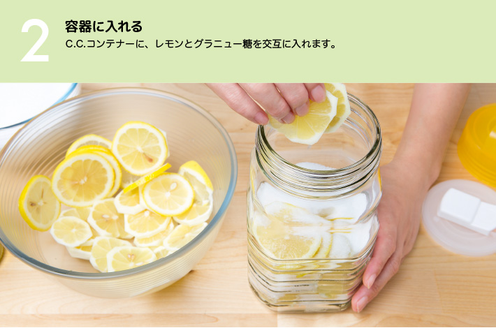 ２）容器に入れる：C.C.コンテナーに、レモンとグラニュー糖を交互に入れます。