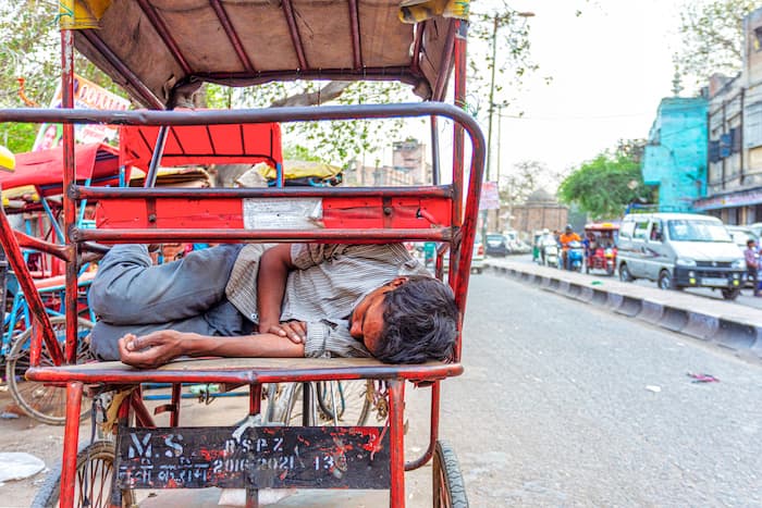 インドの自転車タクシーで眠る男
