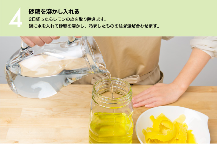 ４）砂糖を溶かし入れる：2日経ったらレモンの皮を取り除きます。鍋に水を入れて砂糖を溶かし、冷ましたものを注ぎ混ぜ合わせます。