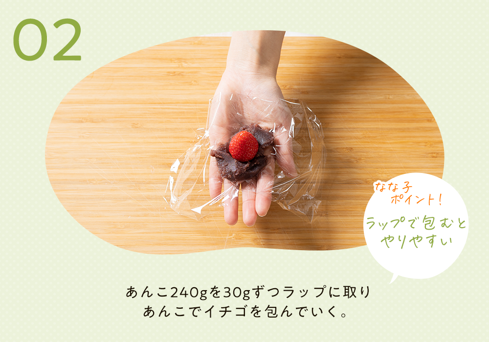 手のひらにラップを敷いて、その上にあんこを適量、
        　　　　　　　　　　　　　　　　　　　　　苺を一つ乗せた様子。